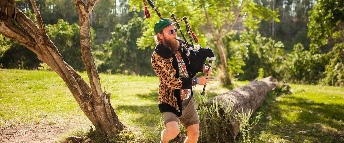 Jungle Love Festival patron playing bagpipes while dancing