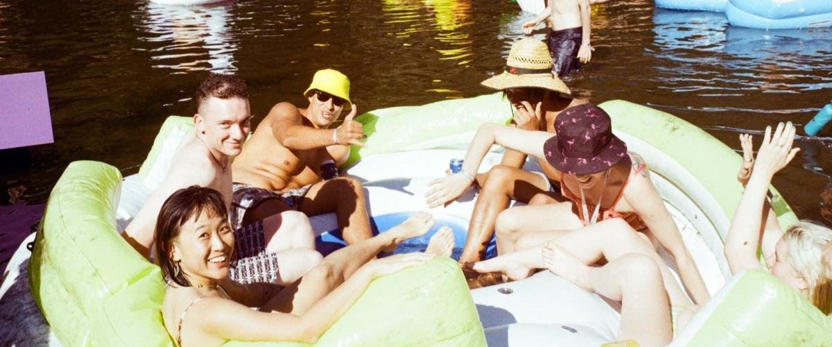 five people in a large inflatable couch on the river